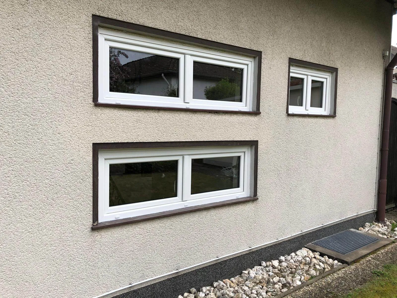 Weiße Kunststofffenster in einer verputzten Fassade nach dem Austausch