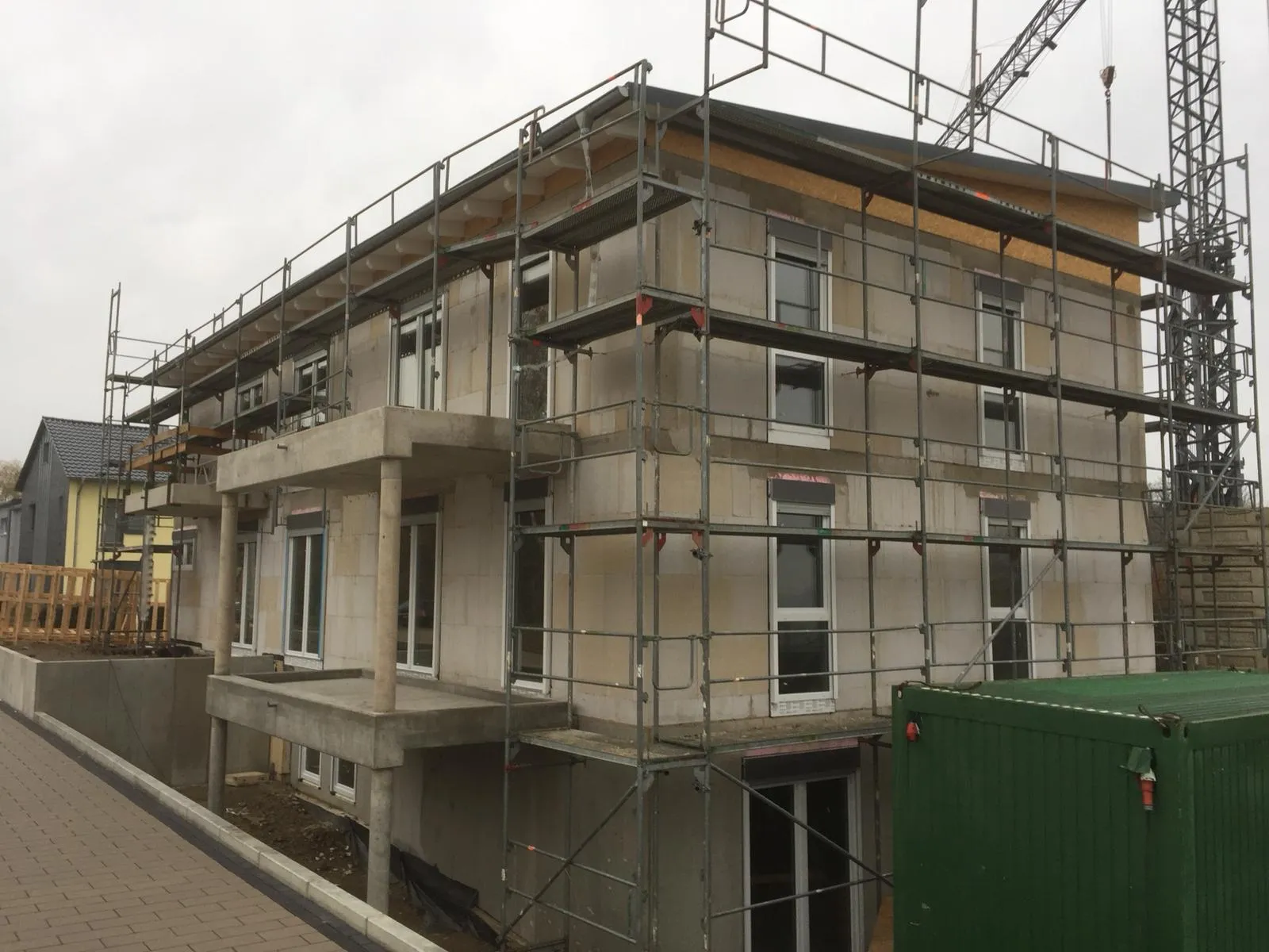 Eingerüstetes Wohnhaus, bei dem die neuen Fenster bereits eingebaut sind