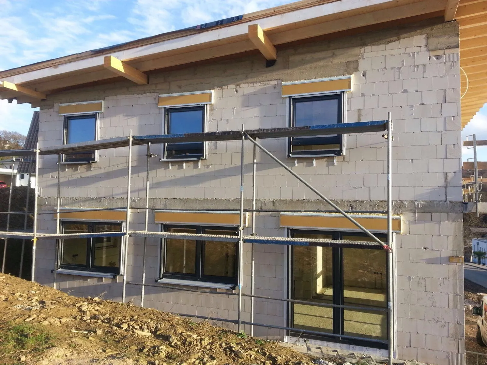 Neubau mit mehreren eingebauten Fenstern, Gerüst steht noch vor der Fassade